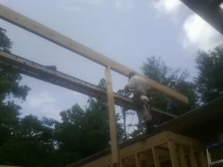 Carpenter setting a ridge beam over a new addition frame — Ice Dam Removal by Roofing Brothers in Sandersville