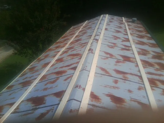 Rusted metal roof panels with new wood purlins before replacement — Storm Damage Roof Repair in Sandersville by Roofing Brothers